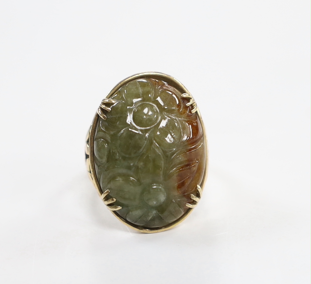 A 14k yellow metal and foliate carved oval cabochon jade set ring, size L, gross weight 7.3 grams.